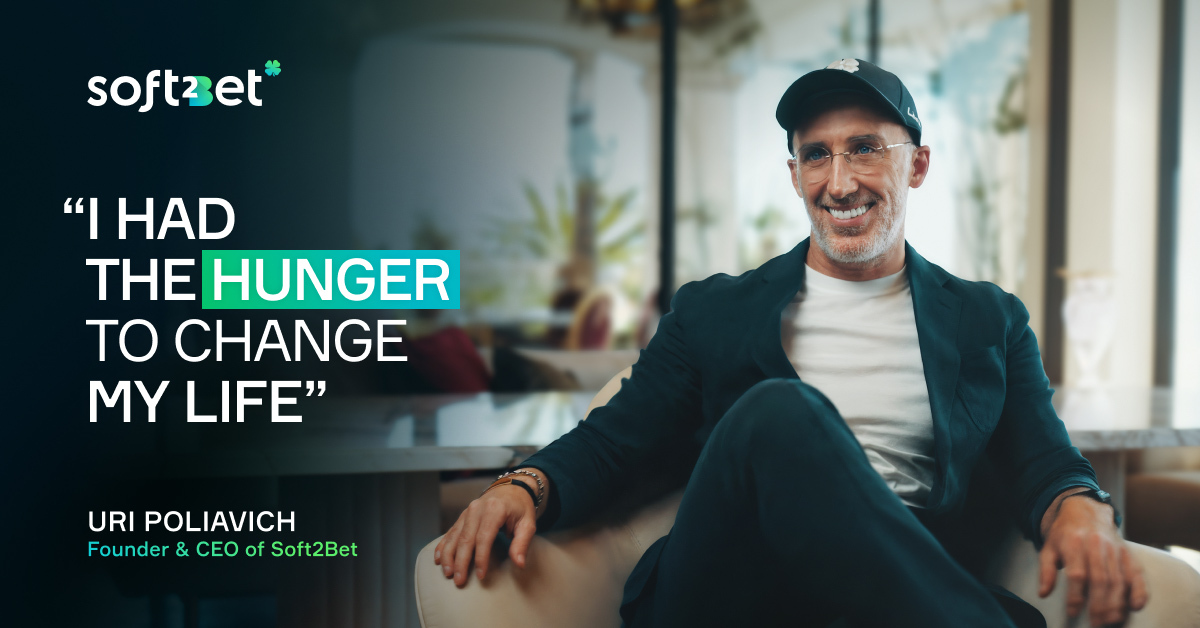 Uri Poliavich, Founder and CEO of Soft2Bet, smiling while seated in a modern office, with quote overlay: "I had the hunger to change my life’’.